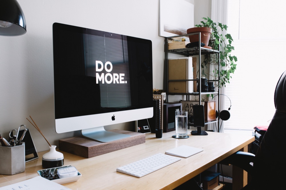 Desk workspace with a “DO MORE.” screen